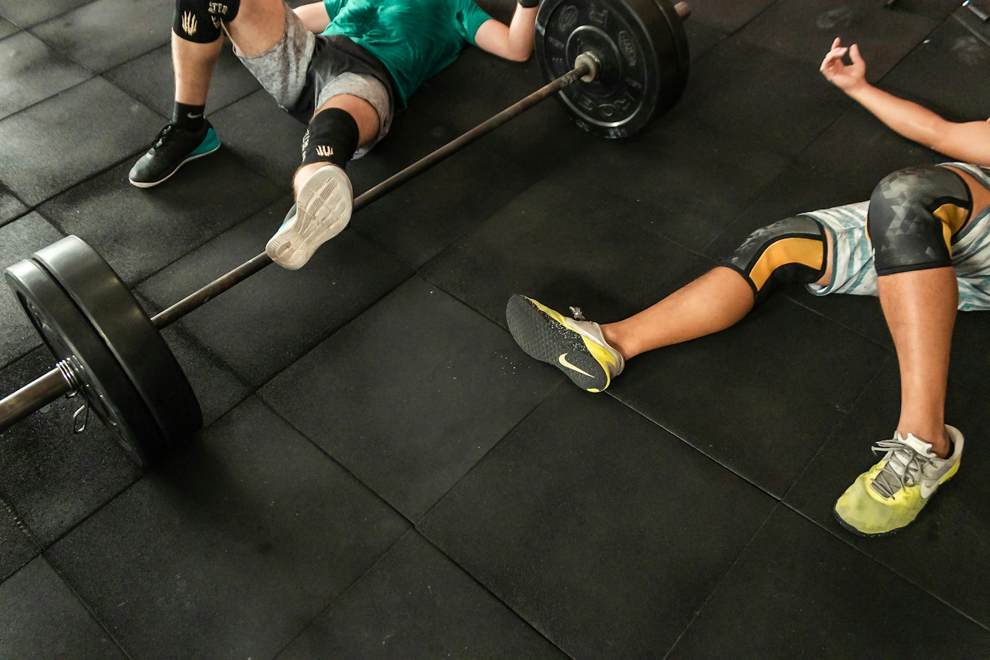 People taking a break together beside weights in a gym.